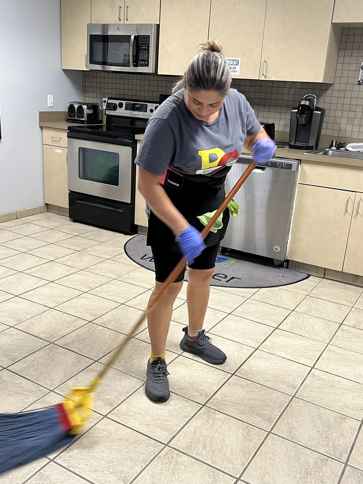 A Rivera Cleaning professional mopping a kitchen floor