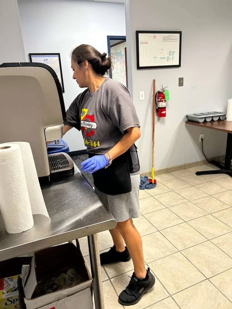 Rivera team member cleaning a stainless-steel counter in a shared kitchen